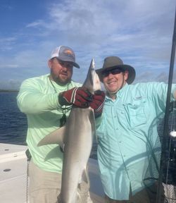 Two anglers displaying a large shark caught while fishing in St. Marys GA waters