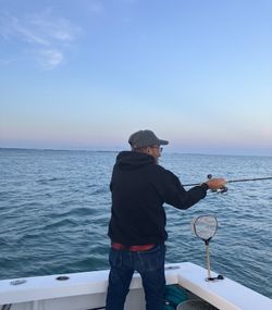 Fishing rod cast over ocean waters from boat deck near Morehead City NC