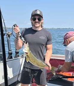 A fisherman holding a 12-inch fish in Cape Vincent