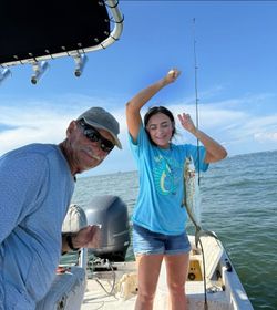 Two people fishing for a spanish mackerel at Fort Morgan