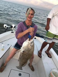 A person fishing for a black drum in Galveston