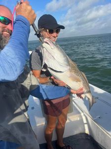 Two people fishing with a big fish in TX