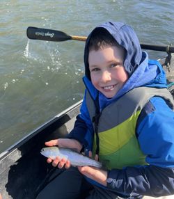 Proud young angler with a small rainbow trout.
