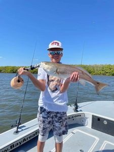 Redfish, a 23-inch saltwater fish, being caught during a fishing tour in Florida.