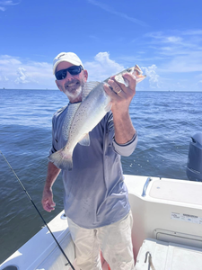 A fisherman holding a caught fish in St. Bernard