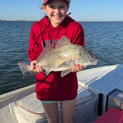 Smiling angler with a hefty black drum catch. 