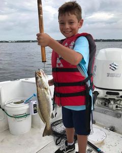 This kid proudly holding his Trophy Trout!