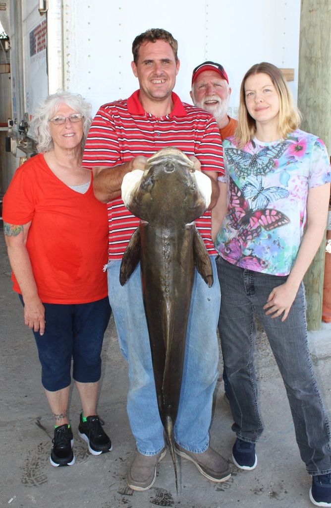 A group of 4 people fishing in an unknown location