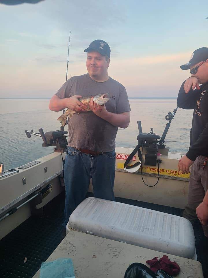 Angler with a 7-inch fish in an unknown location