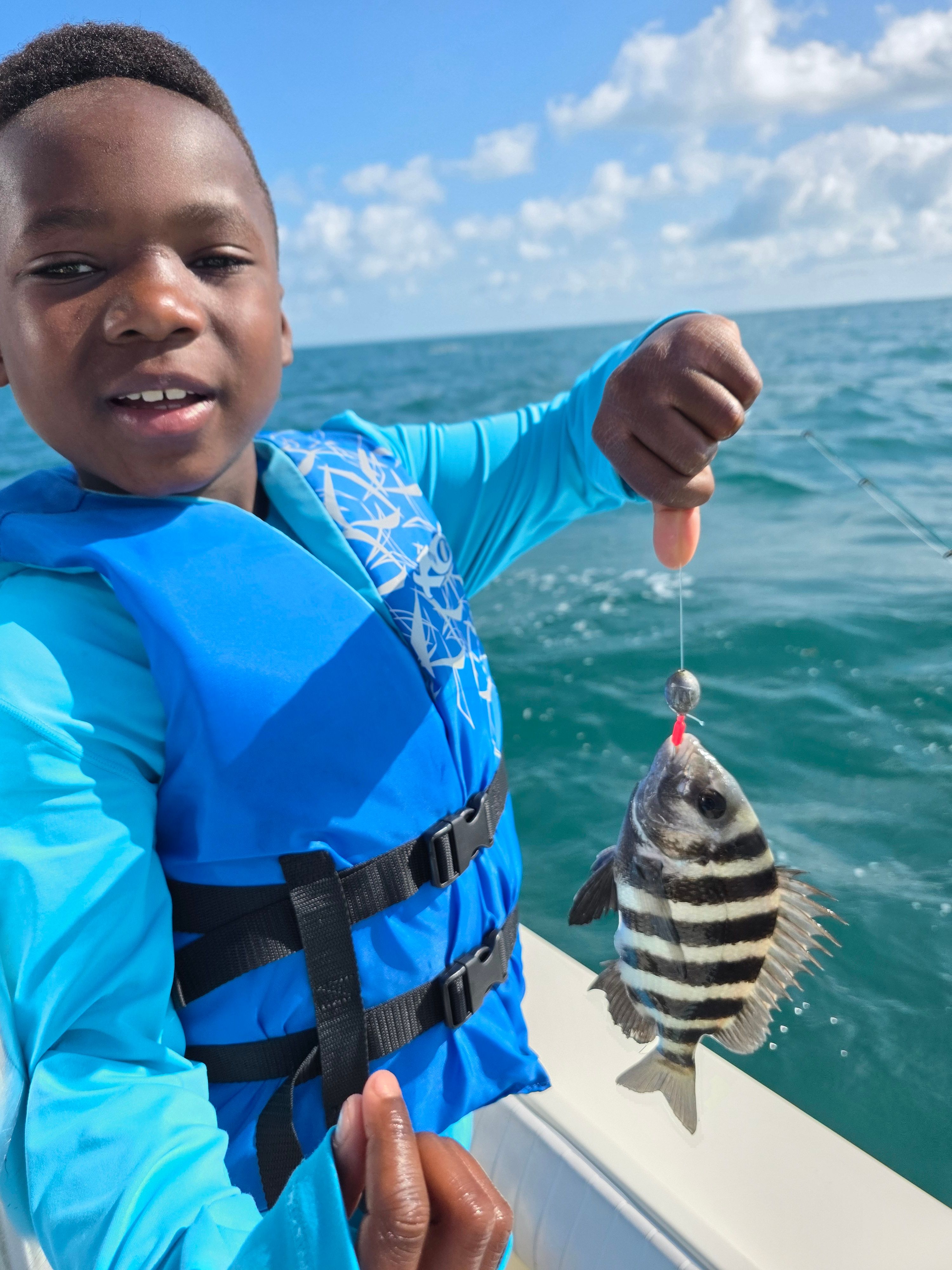 Freshly caught sheepshead fish being held up after successful fishing trip