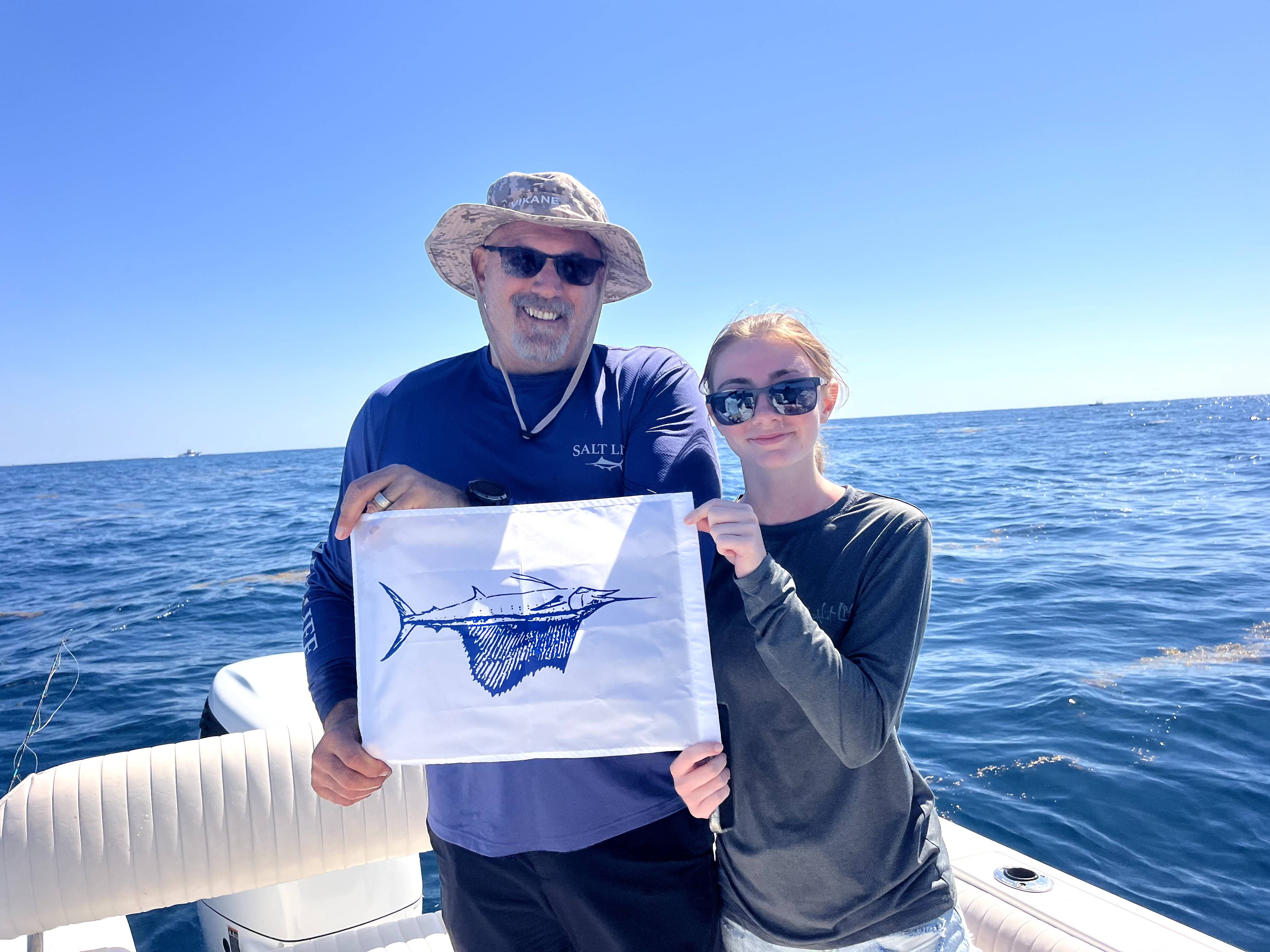 Atlantic sailfish fishing celebration on boat with commemorative flag