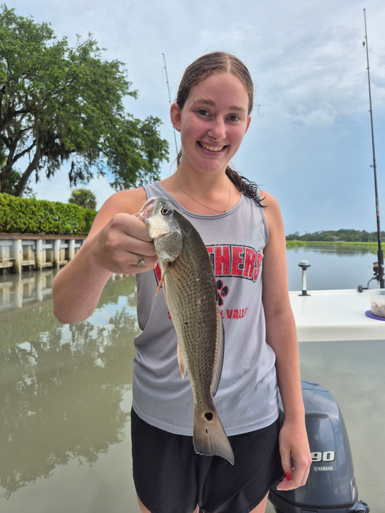 Reeling in a redfish on a partly cloudy day with storm clouds brewing!