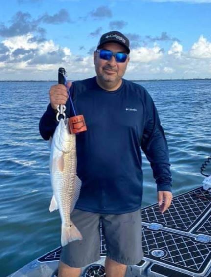 Angler holding a fishing rod with an 18-inch catch at an unknown location
