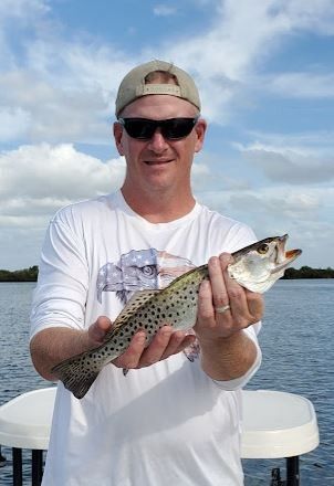 Fisherman reeling in a catch in an unknown location
