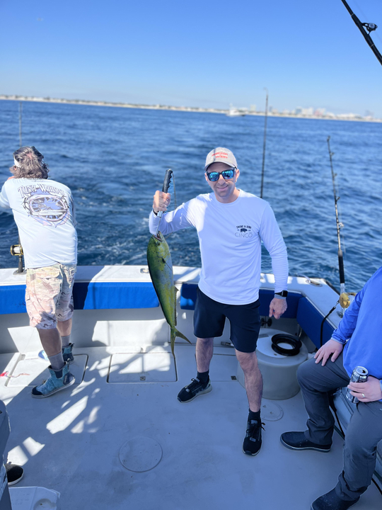 Reeling in a good catch on a beautiful day out at sea.