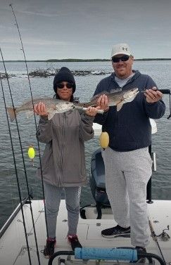 Two people fishing at a scenic location