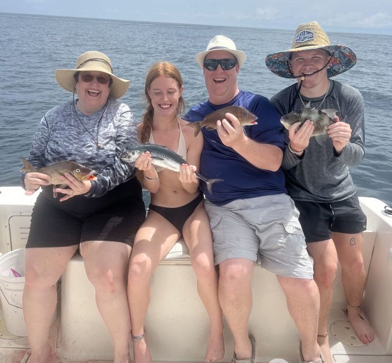 4 fishing people with big fish at unknown location