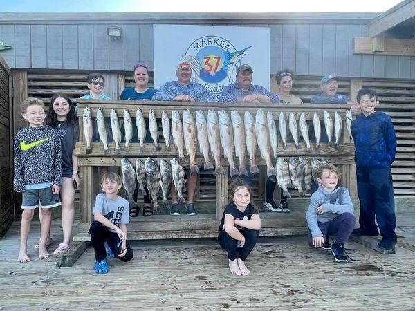 Group of 12 people fishing at unknown location