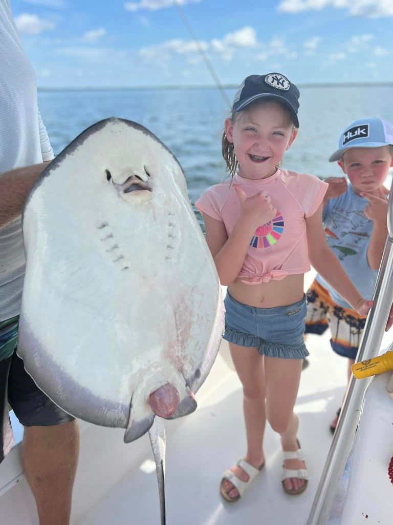 A fisherman holding a 24-inch fish