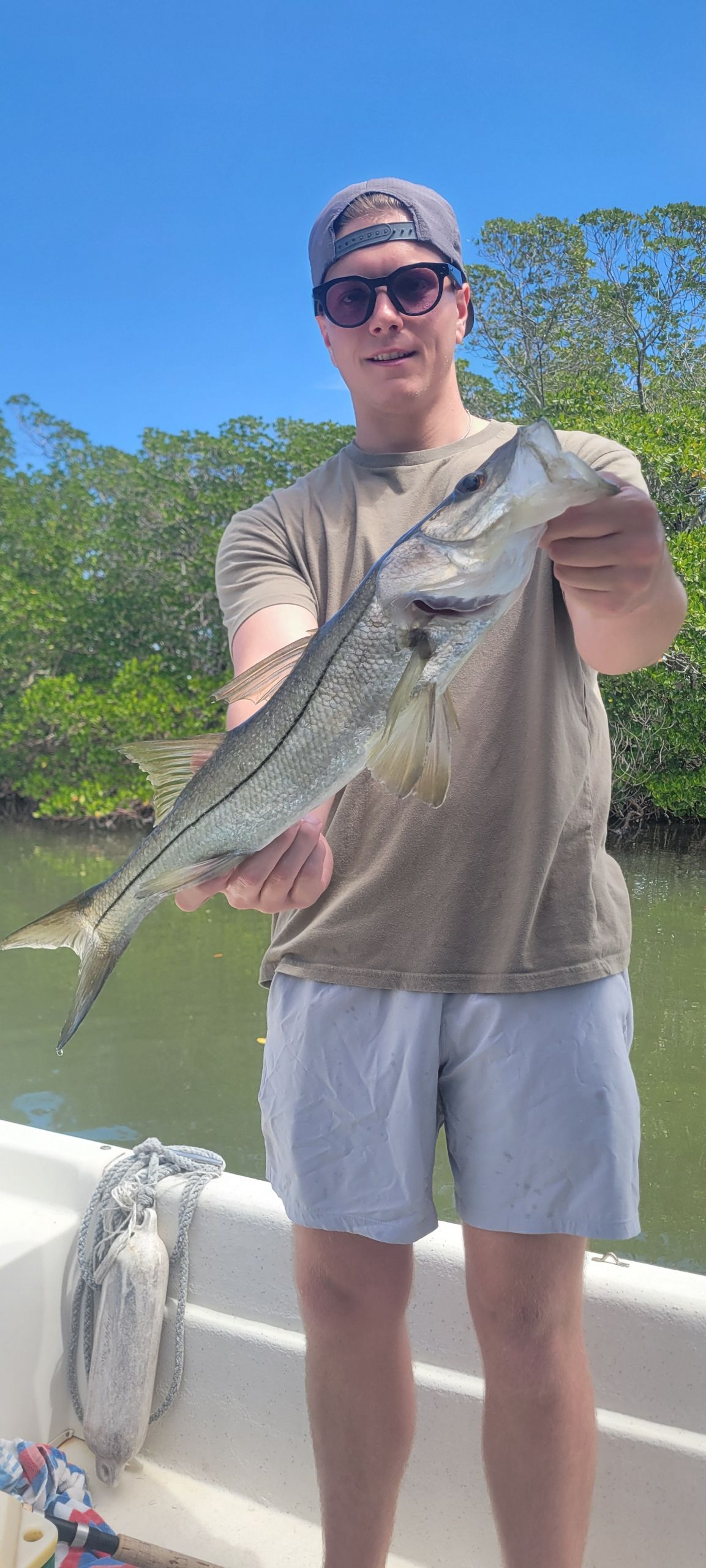 Angler holding freshly caught snook on fishing boat