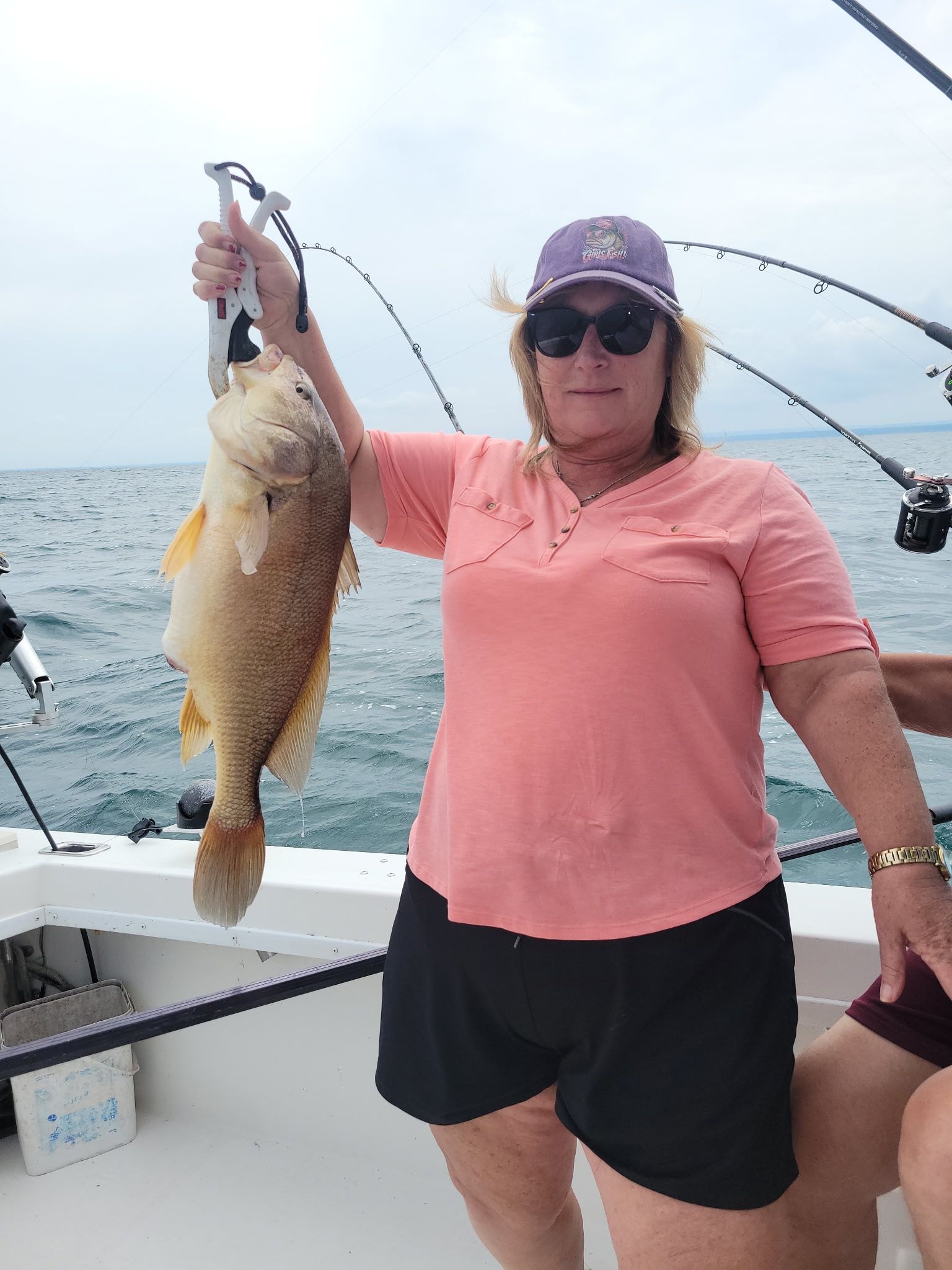Angler holding freshwater drum fish on fishing boat
