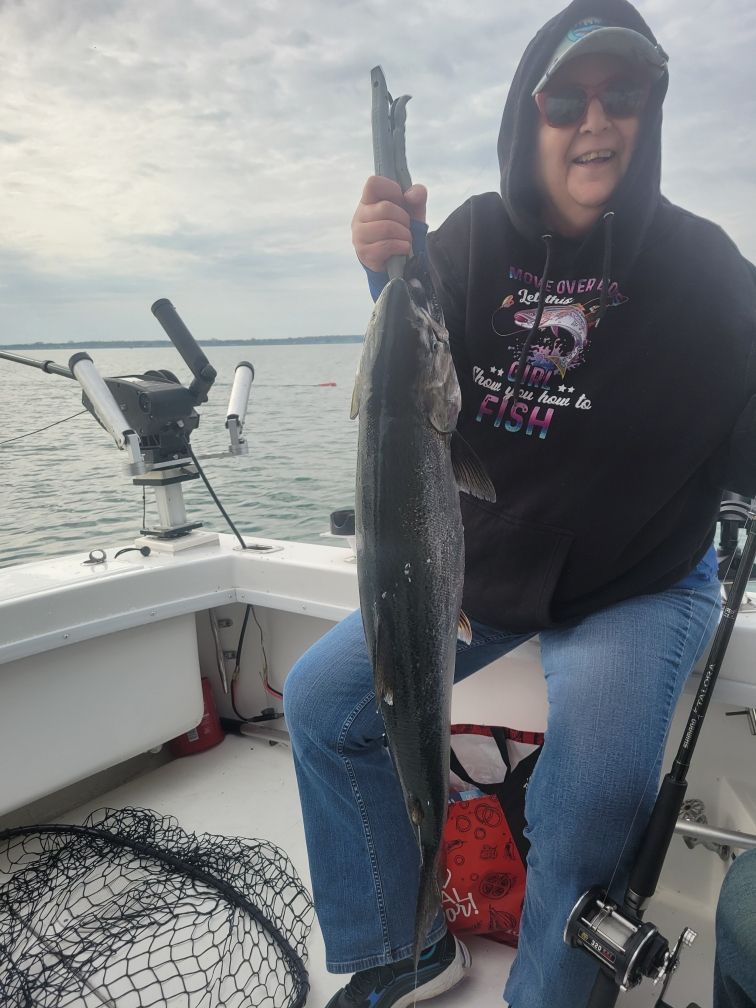 A person fishing with a 27-inch fish
