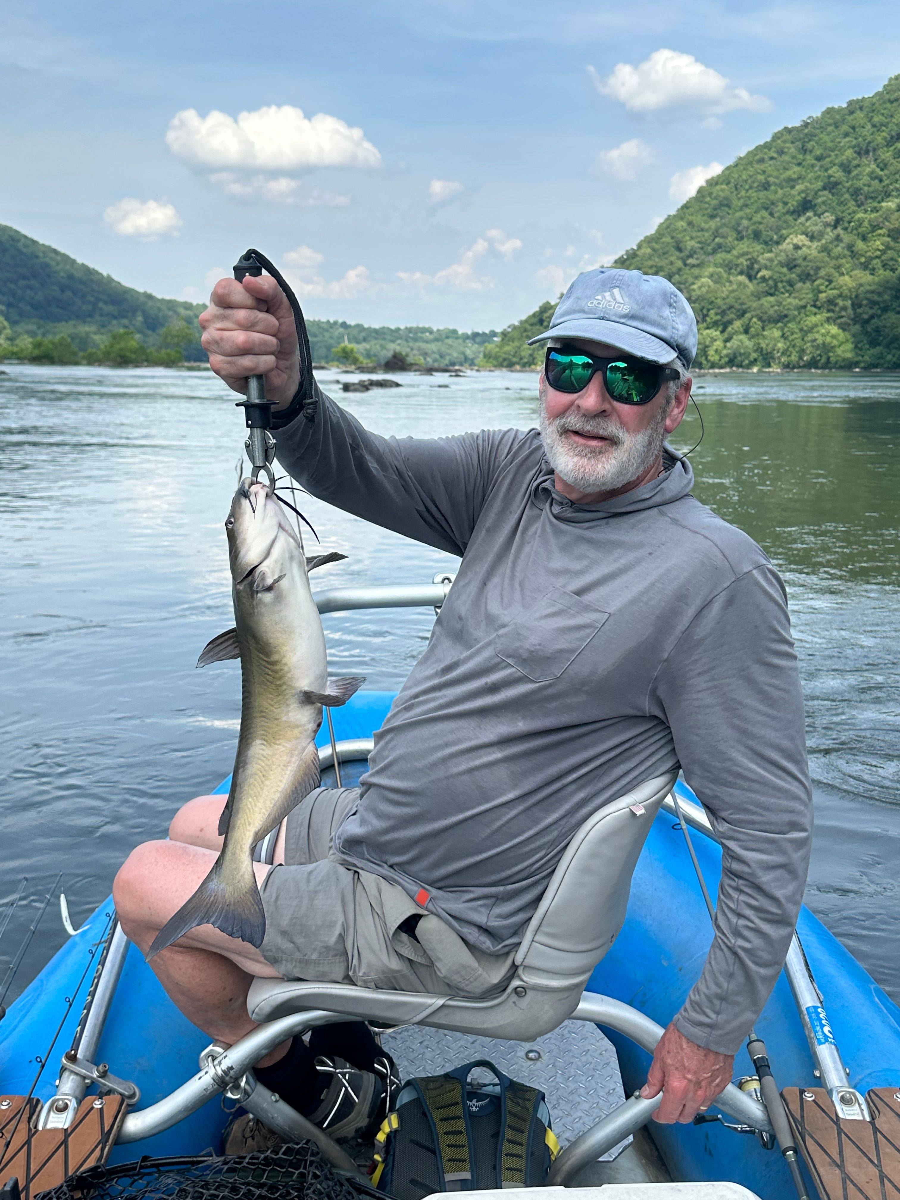 Angler holding a freshly caught channel catfish on a boat during a fishing trip