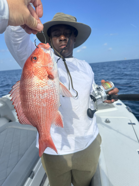 Reeling in a Red Snapper during a partly cloudy day at the beach!
