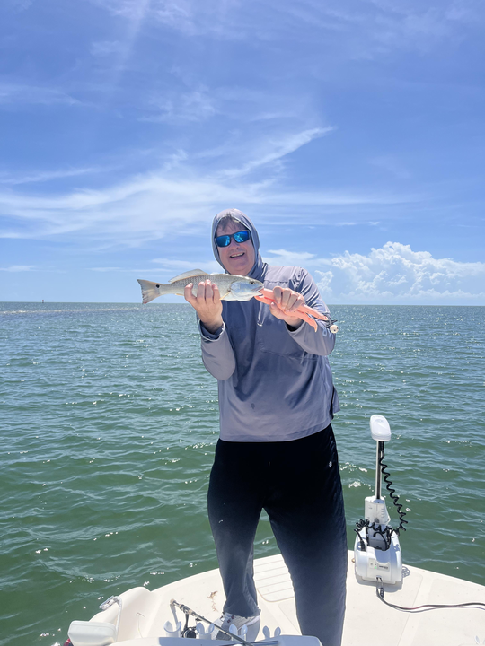 Reeling in a redfish with finesse in partly cloudy skies!