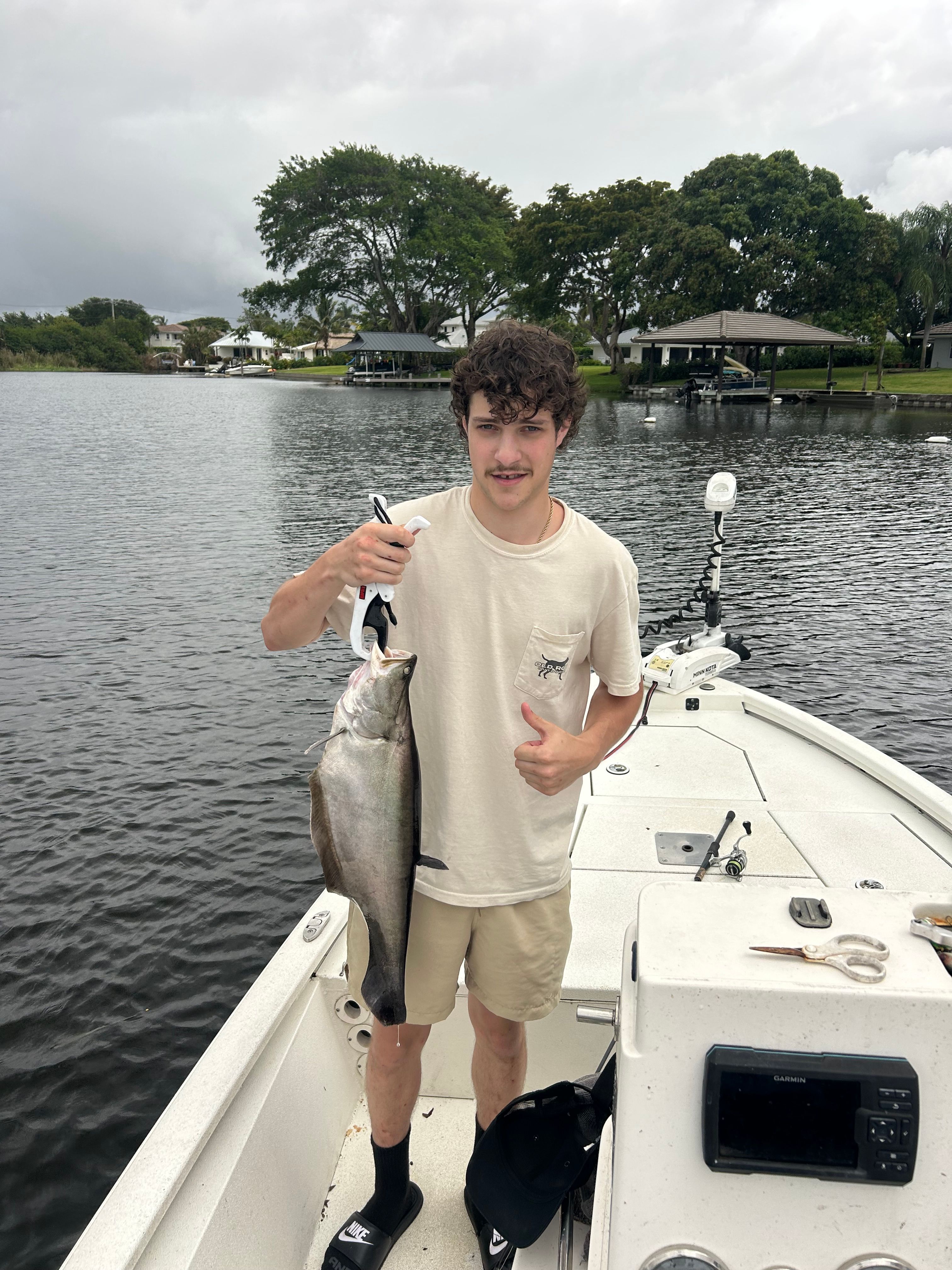 Angler holding freshly caught fish on fishing boat