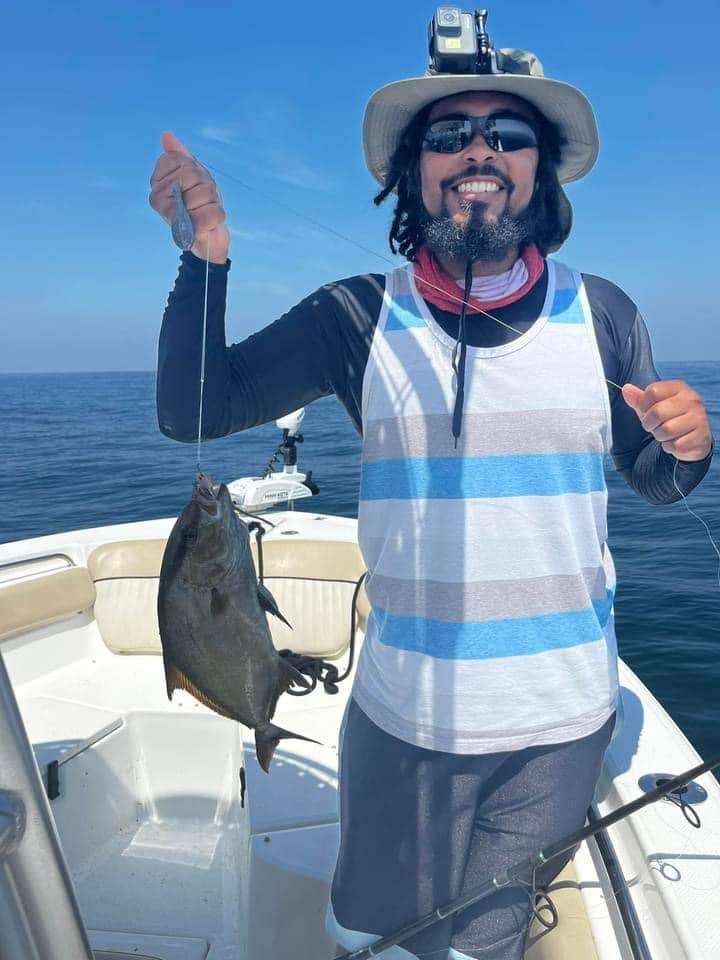 Angler holding a 9-inch fish while fishing at an unknown location.