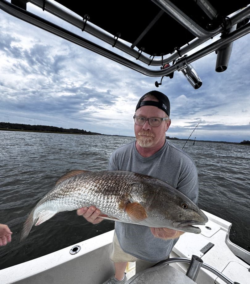Angler fishing with rod and reel at unknown location