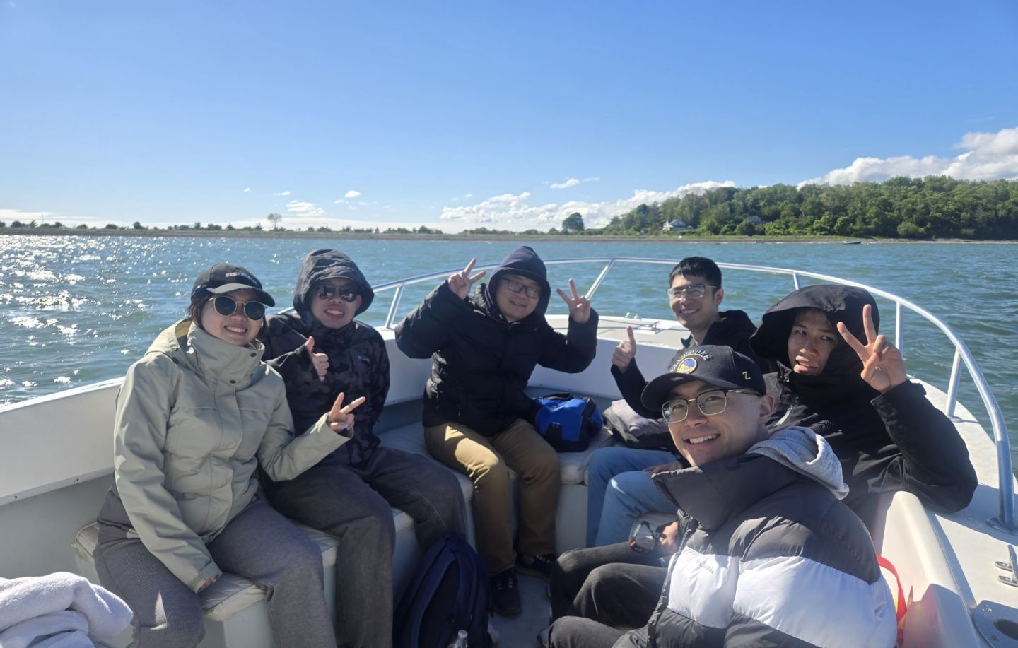 Group of 6 people fishing on an unknown body of water