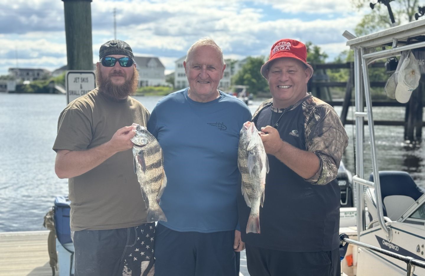 Two black drum fish displayed after successful fishing trip at marina dock