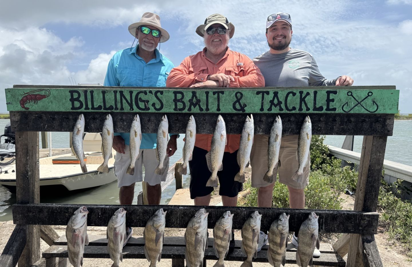 Fishing display showing black drum and speckled trout catch on cleaning station rack
