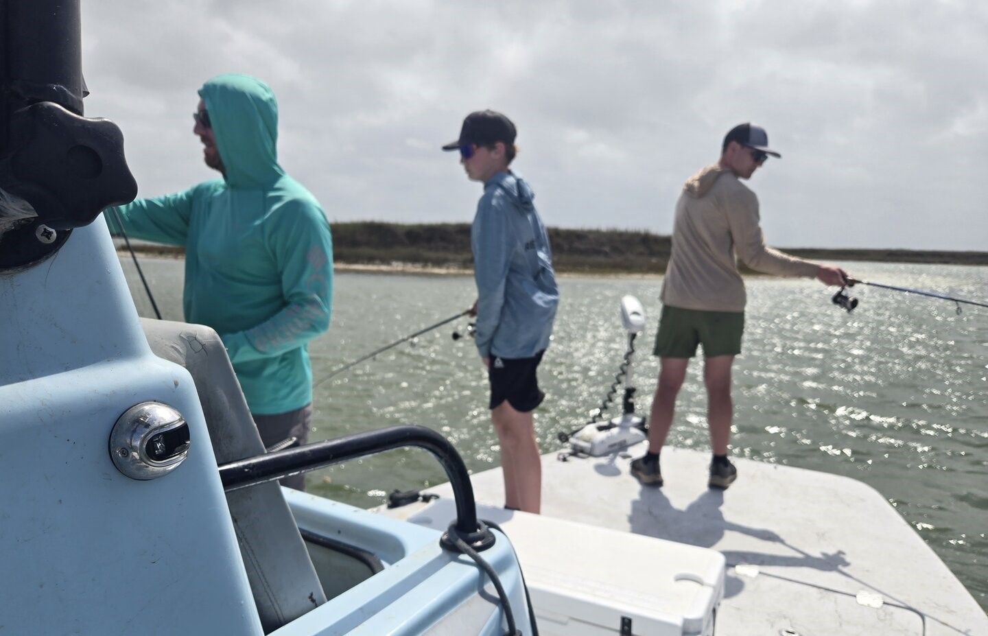 Fishing boat on calm water with anglers holding fishing rods