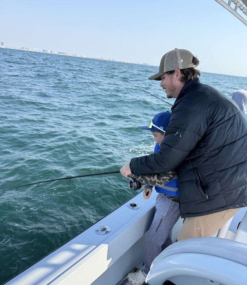 Fishing from boat on open water with fishing rod extended over side