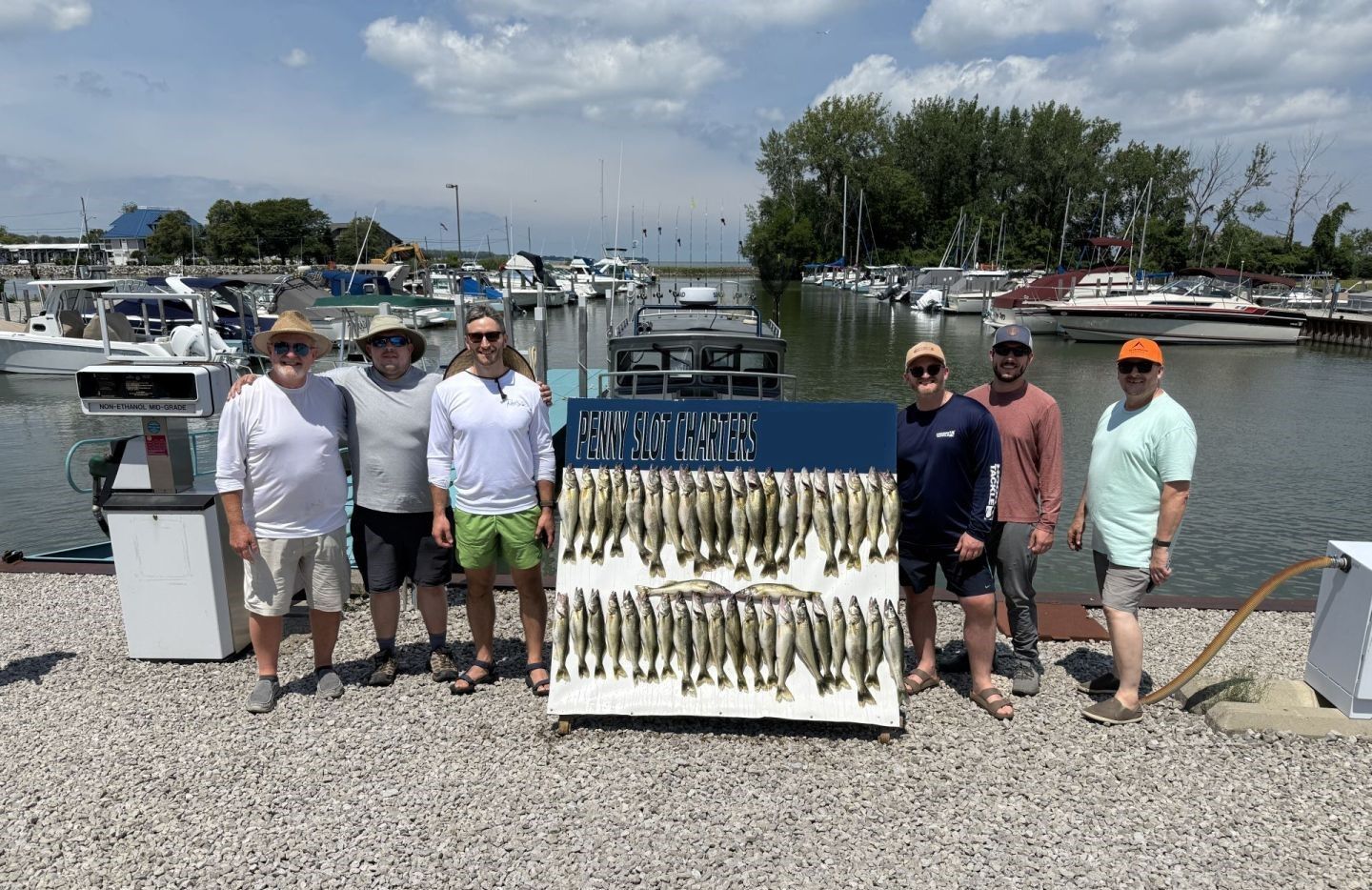 Fishing charter display board showing large catch of fish at marina dock