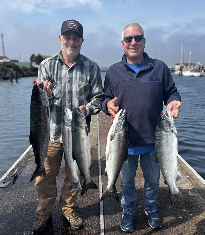 Fresh caught Coho and Chinook salmon displayed on boat dock after successful fishing trip