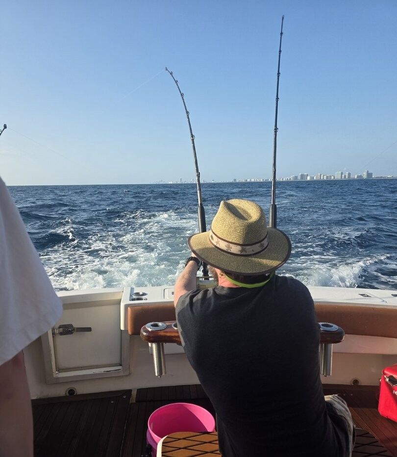 Deep sea fishing boat with fishing rods set up trolling in open ocean water