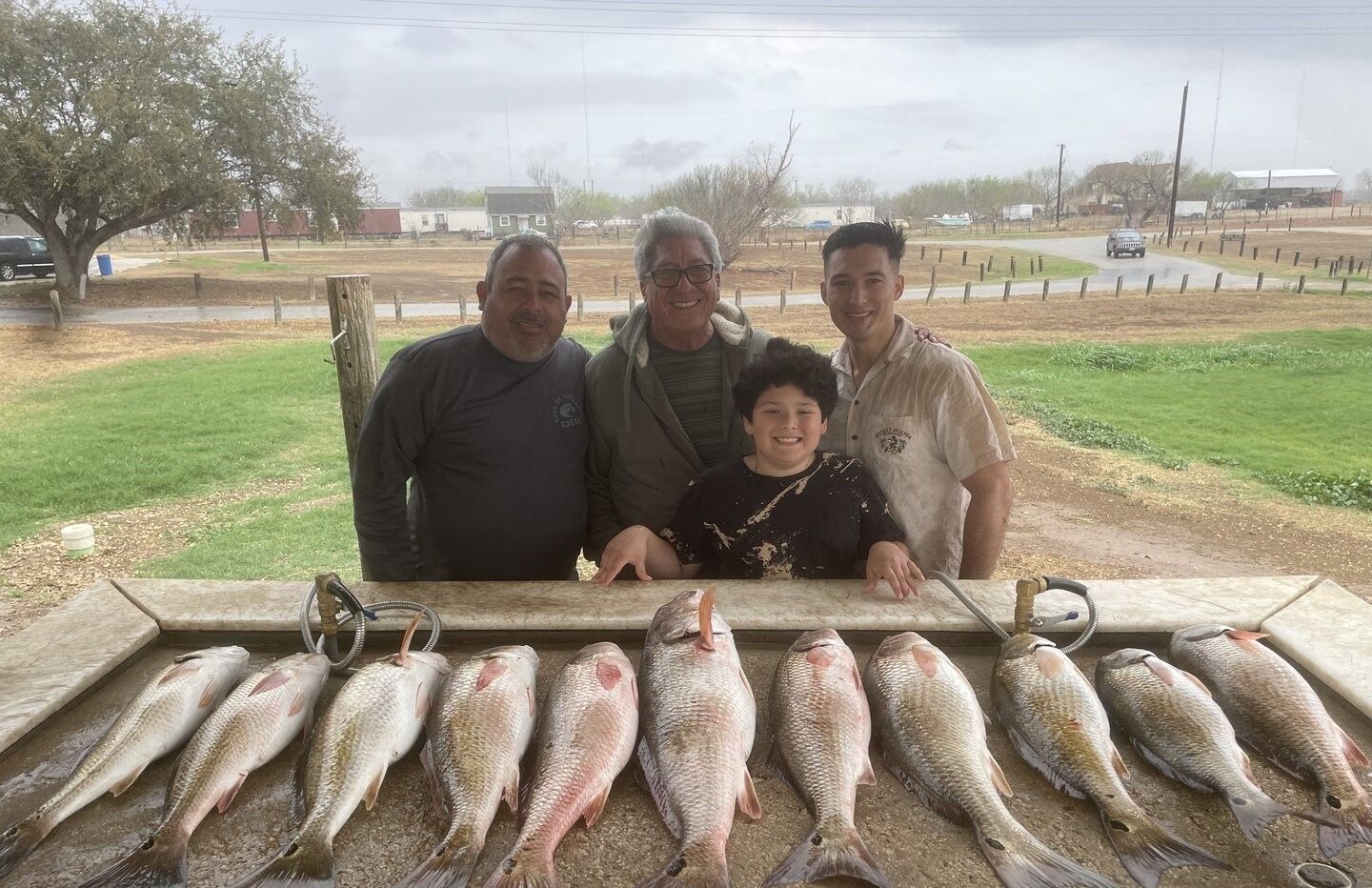 Successful redfish fishing trip showing catch of eight redfish laid out on cleaning station
