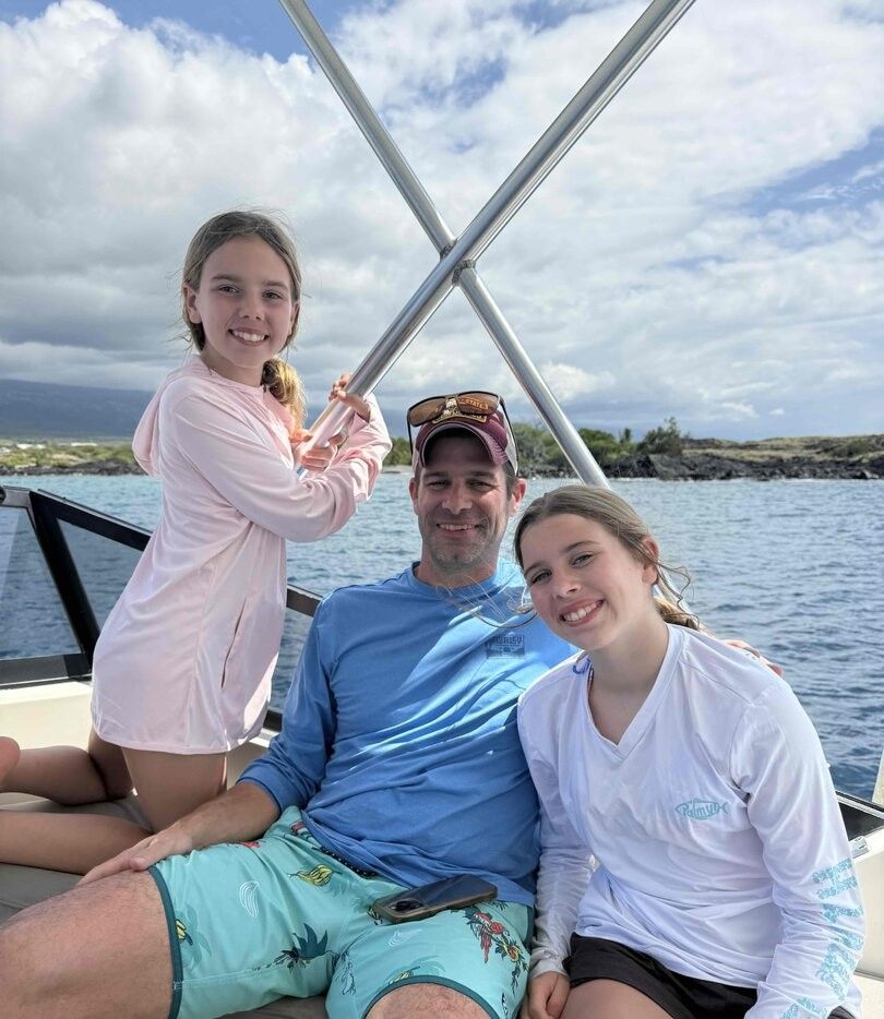 Family enjoying time together on a boat with ocean and cloudy sky in background
