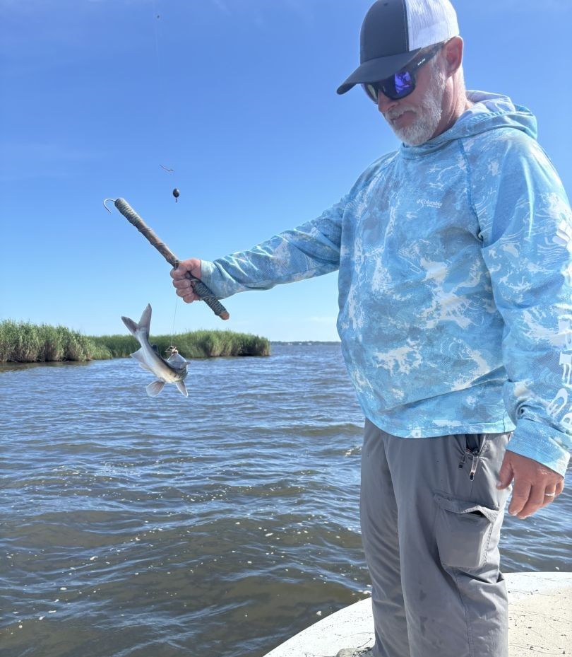 Fish jumping out of water near fishing rod during angling activity