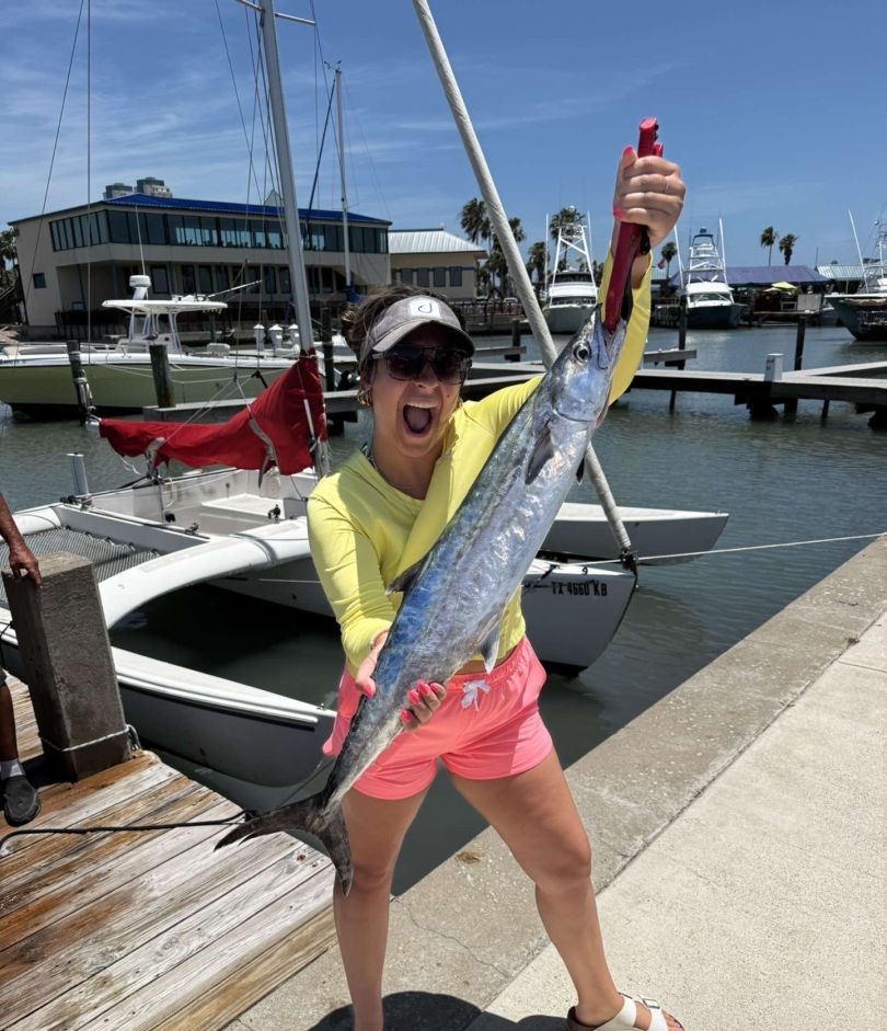 A fisherman holding a King Mackerel fish