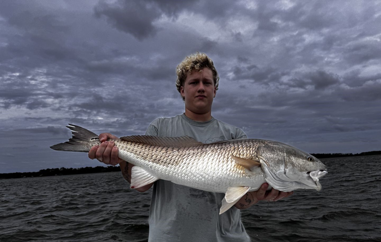 A person fishing at an unknown location