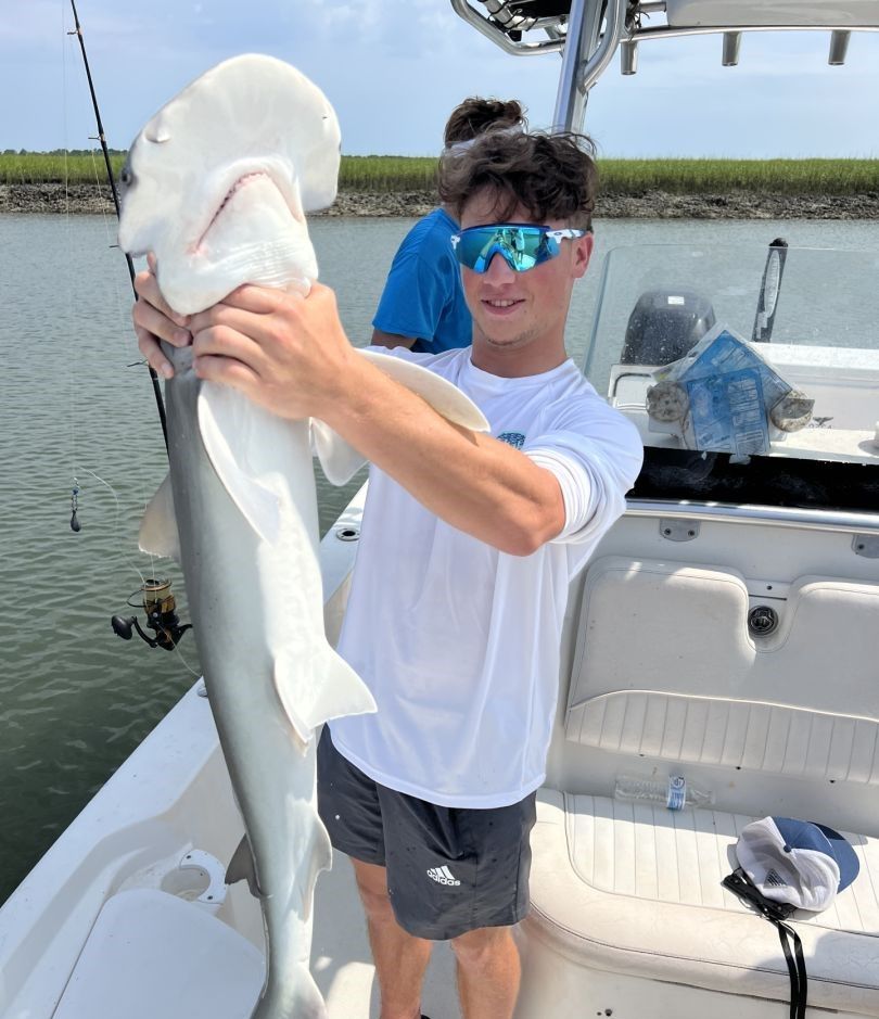 Angler with 9-inch fish enjoying fishing adventure at unknown location