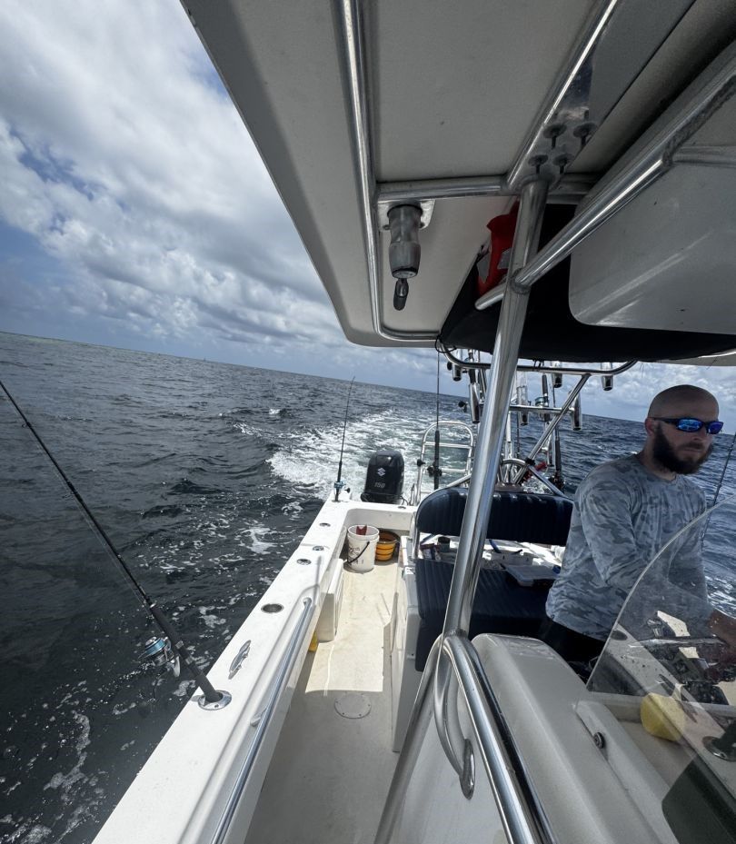 Fishing boat on open water with outriggers and fishing equipment visible