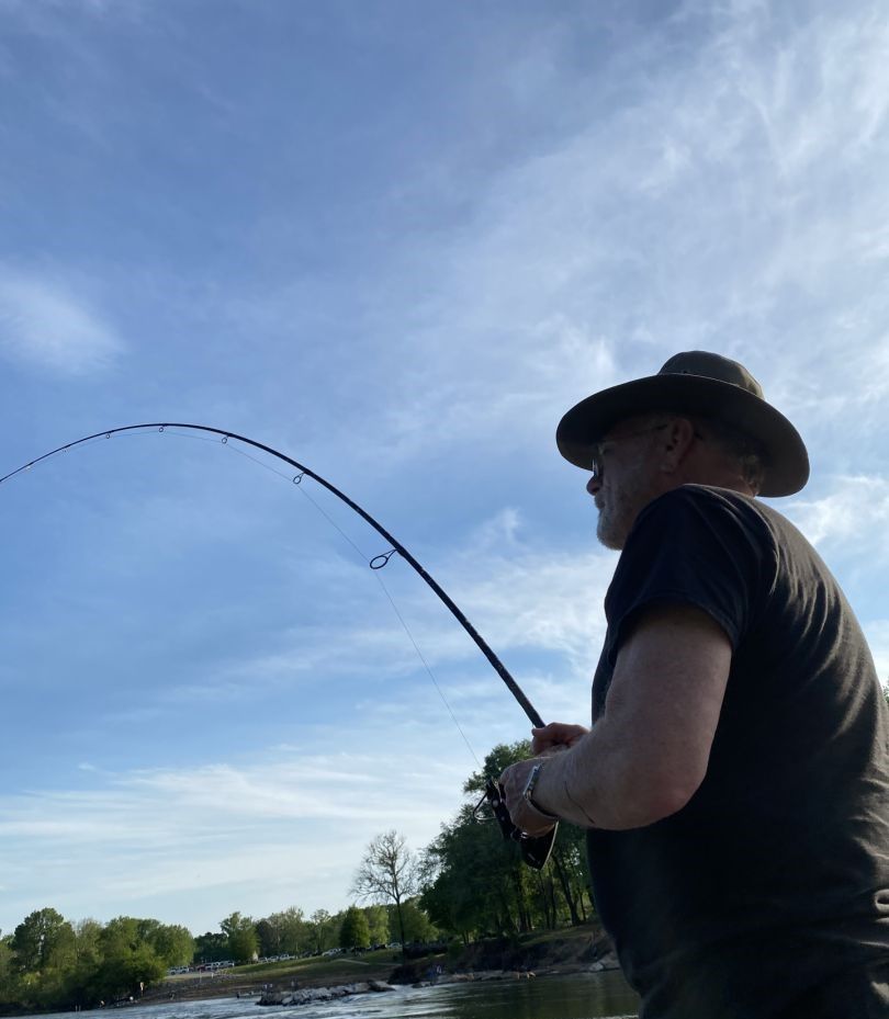 Fishing rod bent with catch during outdoor fishing activity