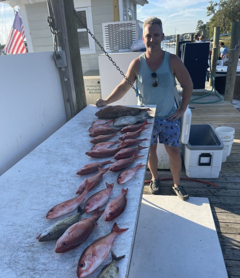 Fresh caught fish displayed on cleaning table at marina dock after successful fishing trip