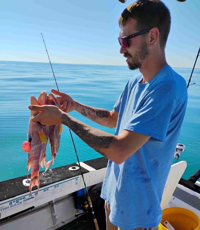 Fresh caught hogfish being held up on fishing boat in calm blue ocean waters
